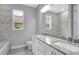 Bright bathroom featuring a double-sink vanity, a large mirror, and a tiled bathtub shower at 30369 Apricot Ave, Eustis, FL 32736