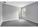 This is a bedroom with gray carpet, a door, and a window, painted light gray at 30369 Apricot Ave, Eustis, FL 32736