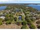 Aerial view of a luxury home with a pool and tennis court, nestled in a lush, green landscape, providing a sense of privacy at 3326 Butler Bay N Dr, Windermere, FL 34786