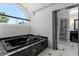 Bathroom featuring a luxurious soaking tub beneath a grand arched window and a marble countertop at 3326 Butler Bay N Dr, Windermere, FL 34786