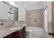 Bathroom features a granite vanity, tiled shower and bath, and natural light from the window at 3326 Butler Bay N Dr, Windermere, FL 34786