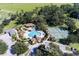 Aerial view of the community pool and tennis courts surrounded by lush landscaping and mature trees at 34626 Salerno Cir, Sorrento, FL 32776
