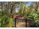 Secluded backyard garden features a bench, mature trees, and vibrant plants at 34626 Salerno Cir, Sorrento, FL 32776
