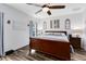 Relaxing bedroom featuring a large bed, wood flooring, and soft natural light from the window at 34626 Salerno Cir, Sorrento, FL 32776