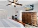 Serene main bedroom featuring a large dresser, closet space and a modern ceiling fan at 34626 Salerno Cir, Sorrento, FL 32776