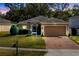 Charming single-story home featuring a brick driveway, manicured lawn, and a two-car garage at 34626 Salerno Cir, Sorrento, FL 32776