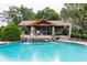 Community pool with cascading waterfall feature by the pool house providing a relaxing atmosphere at 34626 Salerno Cir, Sorrento, FL 32776