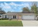 Charming single-story home featuring a well-manicured lawn and a two-car garage at 36 Se Almond Dr, Ocala, FL 34472