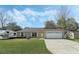 Single-story home with a well-kept lawn and a two-car garage and a trailer parked on the left at 36 Se Almond Dr, Ocala, FL 34472