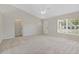 Bright, spacious living room featuring vaulted ceilings, new carpet, and a ceiling fan at 36 Se Almond Dr, Ocala, FL 34472