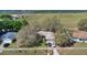 Aerial shot showcasing the home, surrounding landscape, and proximity to open fields at 37149 Sandy Ln, Grand Island, FL 32735