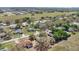 Overhead view of a residential area featuring diverse homes, verdant lawns, and mature trees at 37149 Sandy Ln, Grand Island, FL 32735