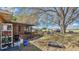 View of the backyard, featuring trees, grass, and a variety of equipment, offering a spacious outdoor area at 37149 Sandy Ln, Grand Island, FL 32735