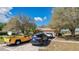 Inviting single-story home with a long driveway and an attached two-car garage, surrounded by mature trees at 37149 Sandy Ln, Grand Island, FL 32735