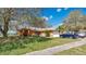 Lovely single-story home with a lush green lawn, mature trees, and an attached two-car garage at 37149 Sandy Ln, Grand Island, FL 32735