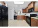 Well-lit kitchen with wooden cabinets, tile flooring, and a view into the adjacent dining area at 3823 Ryegrass St, Clermont, FL 34714