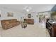 Bright living room with tile flooring, two brown sofas, ceiling fan, and sliding glass doors to the outdoors at 3823 Ryegrass St, Clermont, FL 34714
