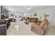 Open-concept living area with tile flooring, comfortable seating, and a view of the adjacent kitchen at 3823 Ryegrass St, Clermont, FL 34714