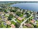 Aerial view of homes near a large lake, featuring lush greenery and enclosed pool areas at 415 Flagler Rd, Winter Haven, FL 33884