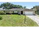 Charming single-story home featuring a well-manicured lawn, attached garage, and mature landscaping at 415 Flagler Rd, Winter Haven, FL 33884