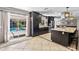 Bright kitchen with dark cabinets, a large island, and a view of the screened-in pool at 415 Flagler Rd, Winter Haven, FL 33884