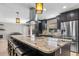 Stylish kitchen featuring an oversized granite island with seating, pendant lighting, and stainless steel appliances at 415 Flagler Rd, Winter Haven, FL 33884
