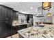 The kitchen features dark cabinets, a stainless steel refrigerator, and a large granite island at 415 Flagler Rd, Winter Haven, FL 33884