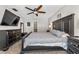 The main bedroom with a large bed, dark furniture, a ceiling fan, a dresser, and a door to the bathroom at 415 Flagler Rd, Winter Haven, FL 33884