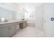 Clean bathroom featuring double sinks, a soaking tub, and elegant tile flooring at 4338 Rhyme St, Kissimmee, FL 34746