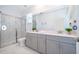 Well-lit bathroom featuring double sinks, a walk-in shower, and modern fixtures at 4338 Rhyme St, Kissimmee, FL 34746