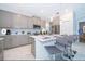 Modern kitchen with grey cabinetry, stainless steel appliances, island with bar seating, and marble floors at 4338 Rhyme St, Kissimmee, FL 34746