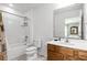 Clean bathroom featuring a shower-tub combo, wooden vanity, and a large mirror reflecting the Primary bedroom at 5260 Oakbourne Ave, Davenport, FL 33837