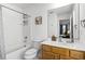 Clean bathroom with a shower-tub combo and a wooden vanity, with a large mirror above reflecting the bedroom at 5260 Oakbourne Ave, Davenport, FL 33837