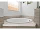 Modern soaking tub with tile surround and natural light at 5260 Oakbourne Ave, Davenport, FL 33837