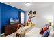 Bright bedroom with twin bed, blue accent wall and large Mickey Mouse decal at 5260 Oakbourne Ave, Davenport, FL 33837