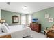 Cozy bedroom with a queen bed, two windows, a wooden dresser with a TV, and quaint, traditional decor at 5260 Oakbourne Ave, Davenport, FL 33837