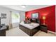 Guest bedroom features a twin bed with dark wood trim, side tables, and a vibrant red accent wall at 5260 Oakbourne Ave, Davenport, FL 33837