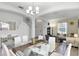 Bright dining room with a glass top table, white chairs, and stylish decor open to living room, perfect for entertaining at 5260 Oakbourne Ave, Davenport, FL 33837