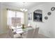Dining area featuring a chandelier, white chairs, and a pass-through window to the kitchen at 5260 Oakbourne Ave, Davenport, FL 33837