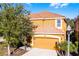 Charming two-story home featuring an orange tile roof and attached garage at 5260 Oakbourne Ave, Davenport, FL 33837