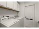 Well-lit laundry room with washer, dryer, and storage cabinets at 5260 Oakbourne Ave, Davenport, FL 33837