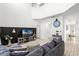 Open-concept living room featuring a large sofa, dark accent wall, and a view into the foyer at 5260 Oakbourne Ave, Davenport, FL 33837