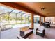 Relaxing screened patio with comfortable seating and dining area overlooking the pool at 5260 Oakbourne Ave, Davenport, FL 33837