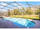 Gorgeous screened-in pool and spa overlooking a lush green backyard at 5260 Oakbourne Ave, Davenport, FL 33837