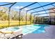 Beautiful screened-in pool and spa area with serene backyard views at 5260 Oakbourne Ave, Davenport, FL 33837