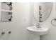 Stylish powder room with a pedestal sink, decorative mirror, and modern fixtures at 5260 Oakbourne Ave, Davenport, FL 33837