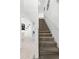 Carpeted staircase with white trim leading to the upper level with a view of the open floor plan at 5260 Oakbourne Ave, Davenport, FL 33837