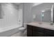 Well-lit bathroom featuring white tile surround, dark vanity, and large mirror at 604 Fortanini Cir, Ocoee, FL 34761
