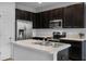 Well-designed kitchen with dark cabinets, stainless steel appliances, and a convenient center island at 604 Fortanini Cir, Ocoee, FL 34761