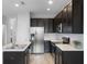 Modern kitchen featuring stainless steel appliances, sleek dark cabinets, and a functional island at 604 Fortanini Cir, Ocoee, FL 34761